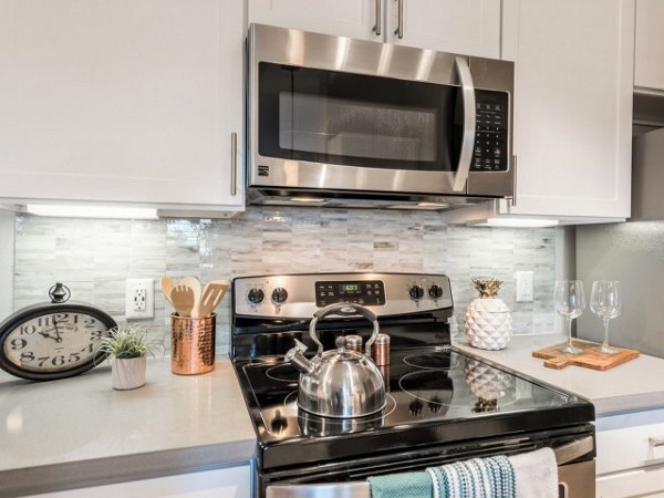 Modern kitchen with stainless steel appliances at Deseo at Grand Mission Apartments