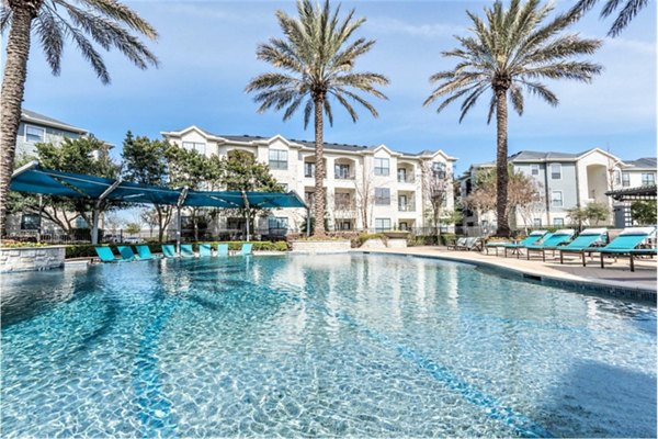 Resort-style pool with lounge chairs at Deseo at Grand Mission Apartments, offering luxury relaxation and recreation options