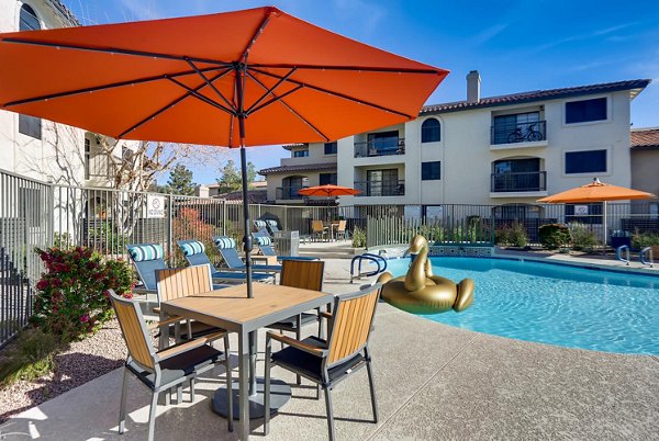 Luxurious resort-style pool at Chazal Scottsdale Apartments with surrounding palm trees, offering a serene outdoor experience for residents