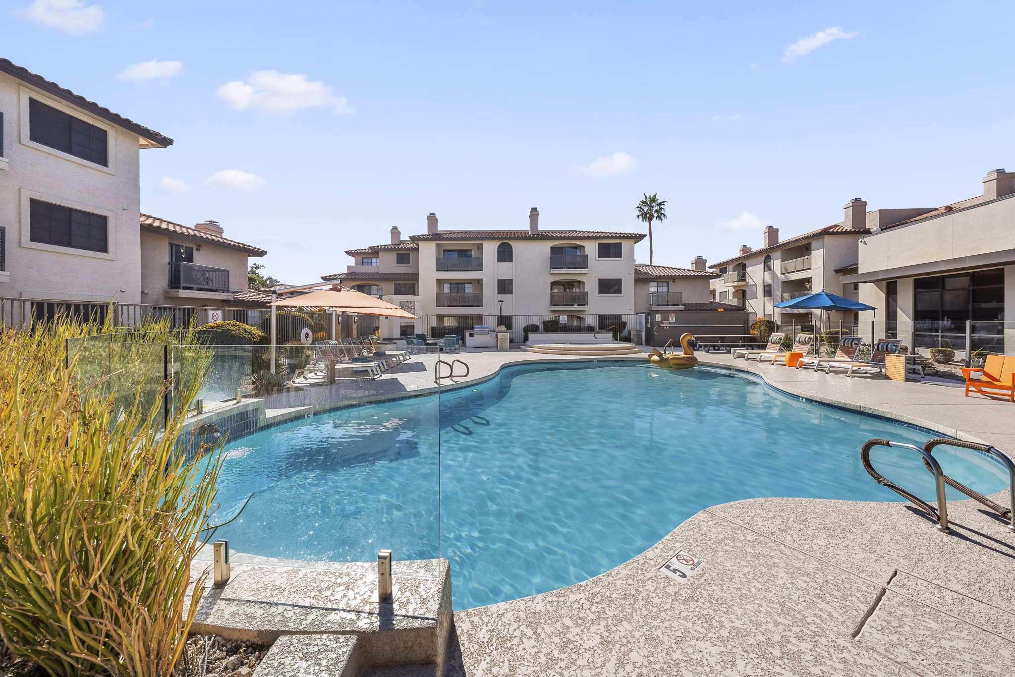Luxurious outdoor pool with sun loungers at Chazal Scottsdale Apartments