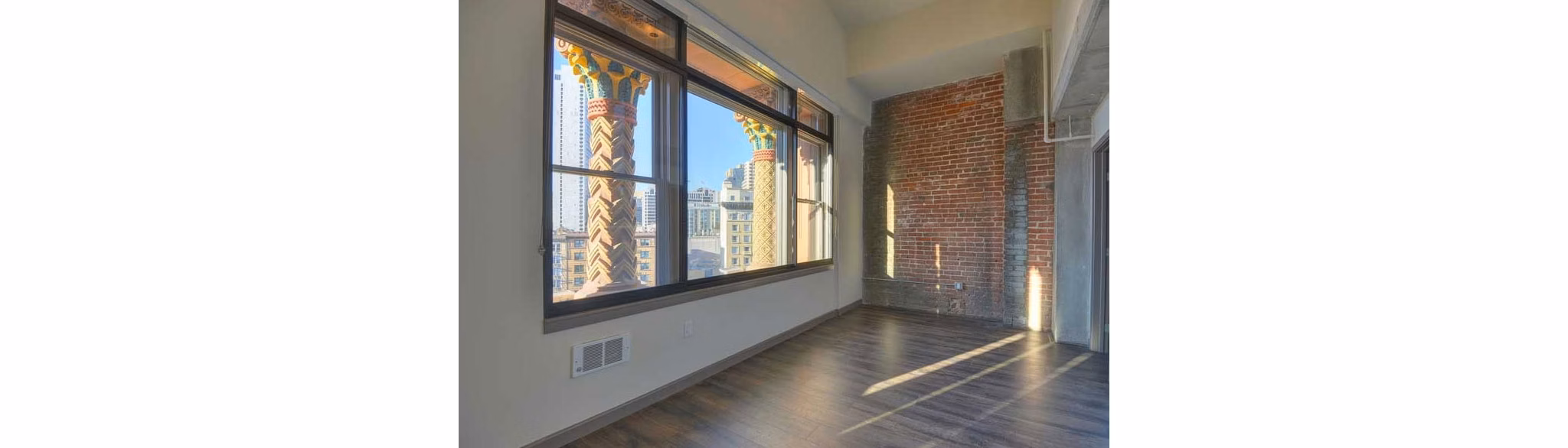 Bedroom with elegant decor and large windows in The Wilson Building Apartments