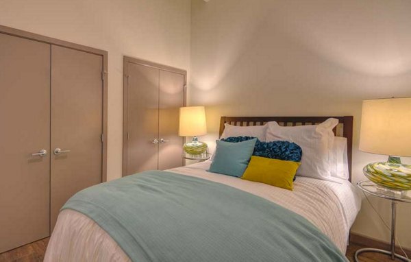 Cozy bedroom featuring elegant decor and natural light at The Wilson Building Apartments