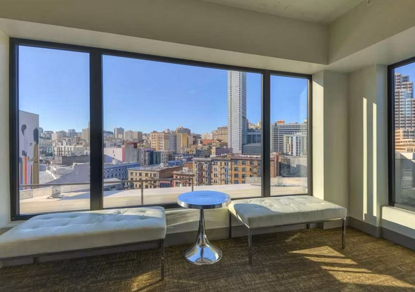 Spacious living room with modern decor and large windows in The Wilson Building Apartments