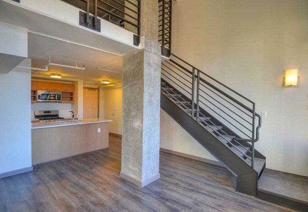 Spacious living room with modern decor and hardwood floors at The Wilson Building Apartments