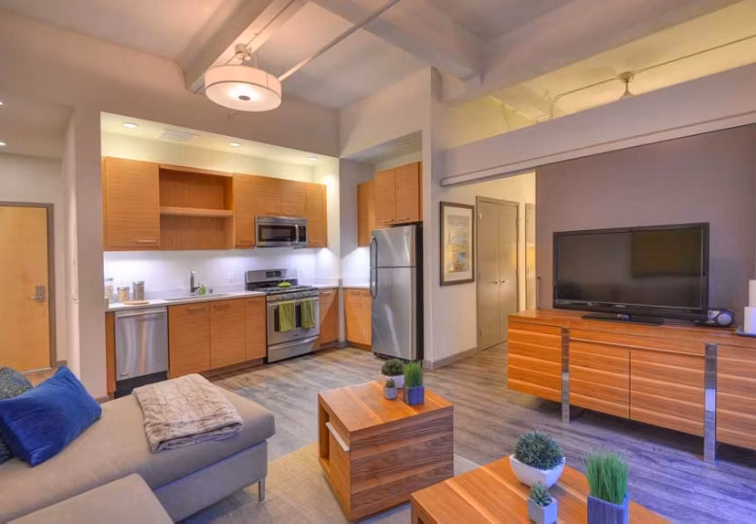Spacious living room featuring modern furnishings and large windows in The Wilson Building Apartments