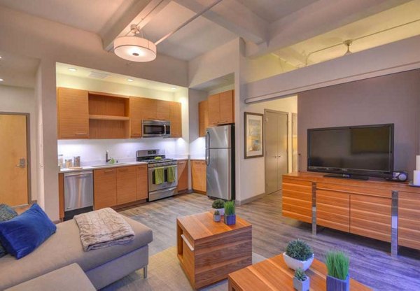 Spacious living room featuring modern furnishings and large windows in The Wilson Building Apartments