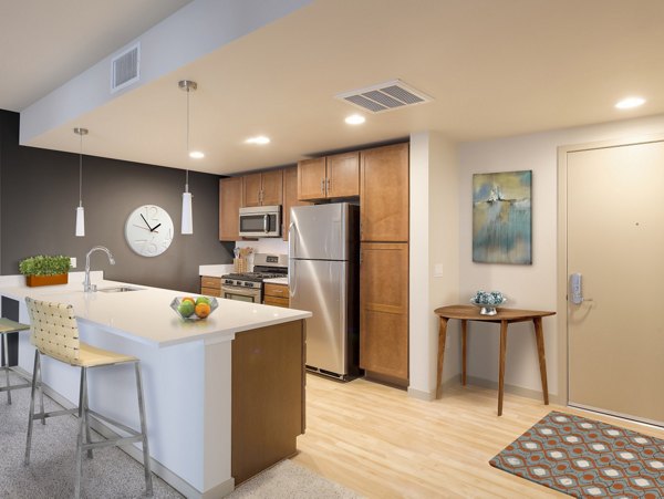 Modern kitchen with stainless steel appliances and quartz countertops at 121 Tasman Apartments