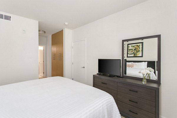 Bedroom featuring sleek design and elegant furnishings at mResidences Redwood City Apartments