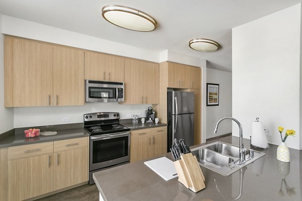 Modern kitchen with stainless steel appliances in mResidences Redwood City Apartments