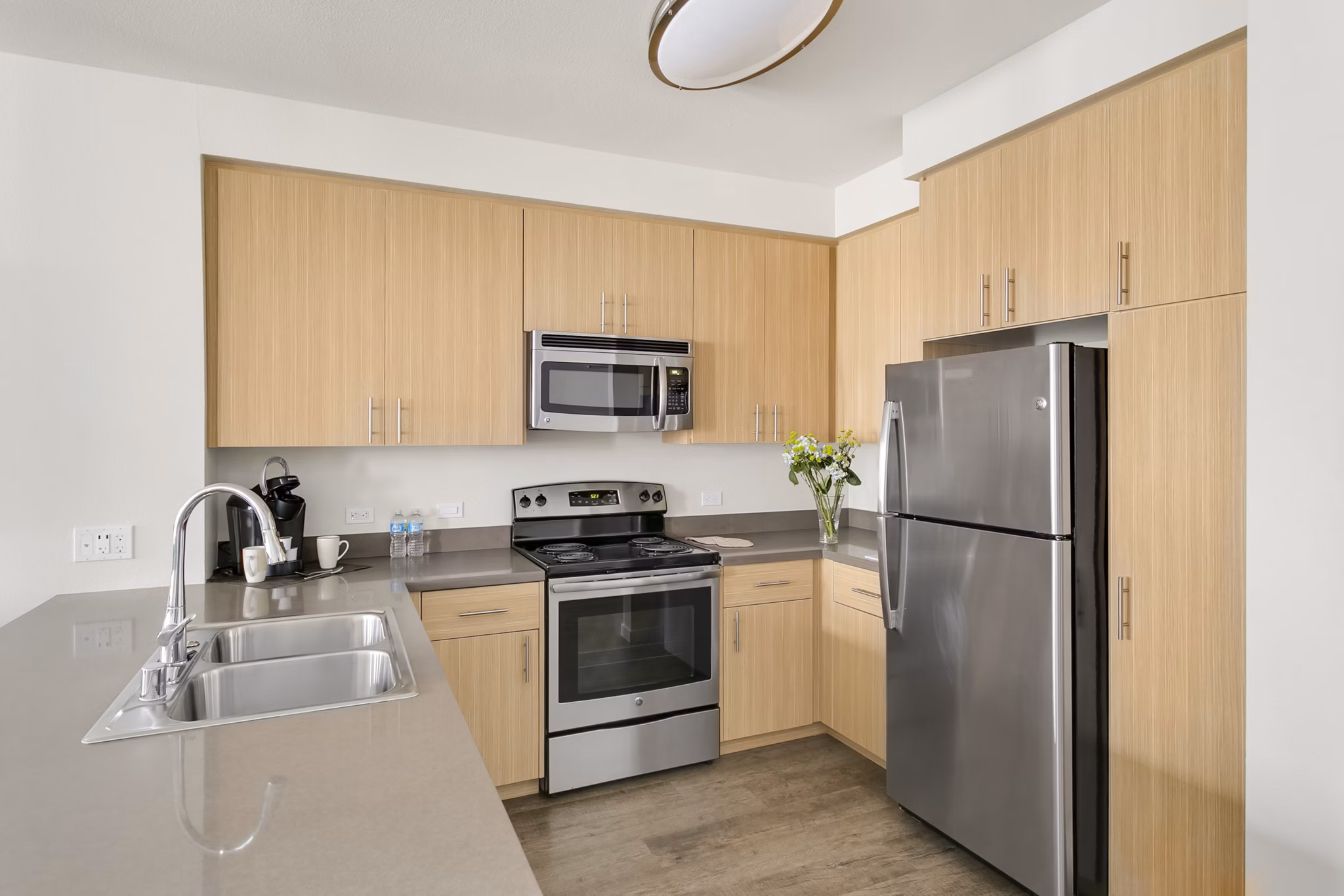 Kitchen featuring modern appliances and granite countertops in mResidences Redwood City Apartments