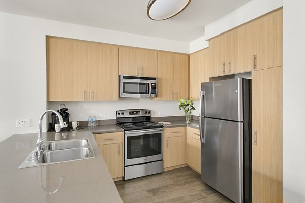 Kitchen featuring modern appliances and granite countertops in mResidences Redwood City Apartments