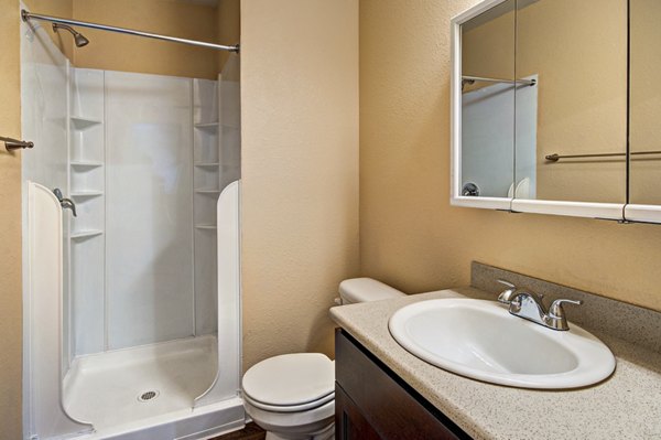 Modern bathroom with sleek fixtures and large mirror at Central Park East Apartments