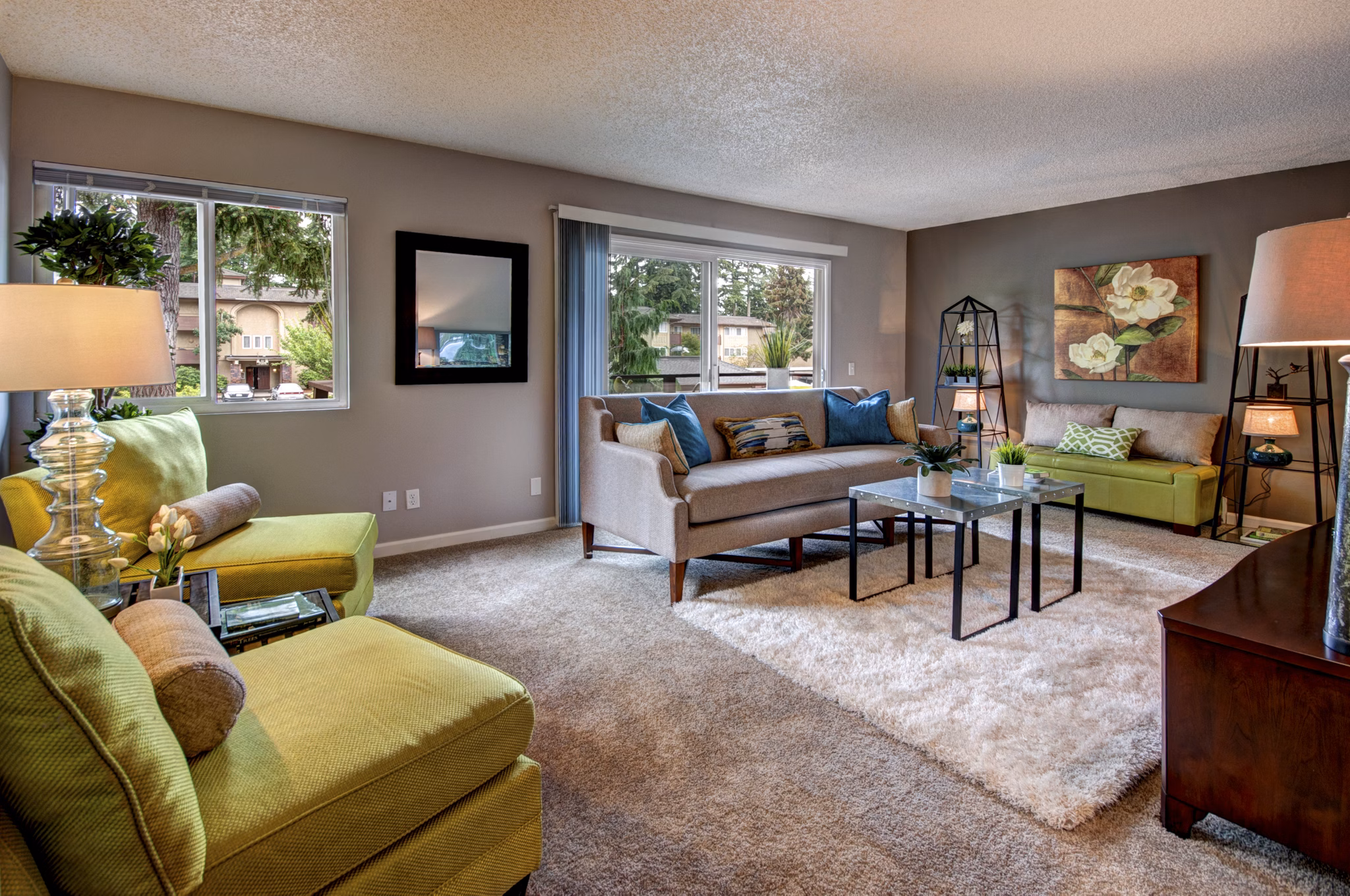 Modern living room with plush seating and large windows at Central Park East Apartments