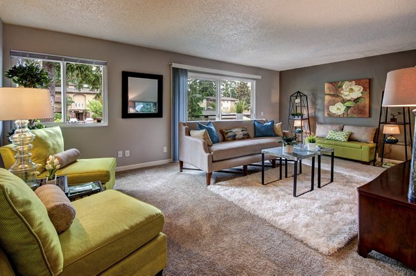 Modern living room with plush seating and large windows at Central Park East Apartments