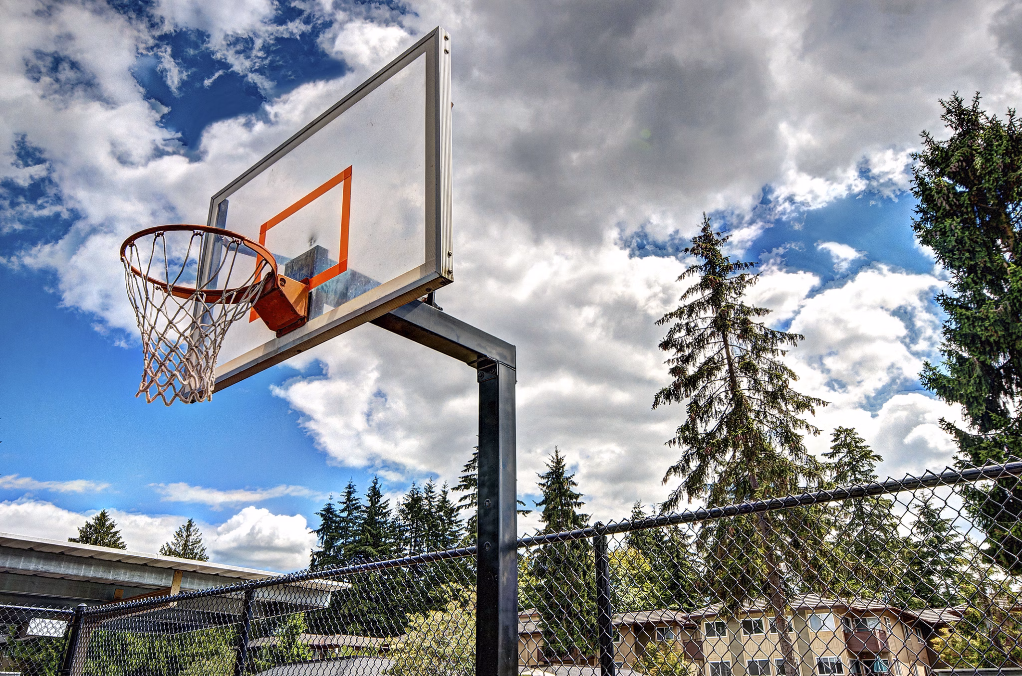 Indoor basketball court with polished wooden flooring at Central Park East Apartments' recreation center