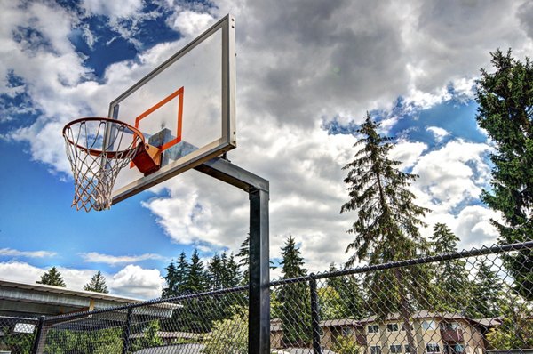 Indoor basketball court with polished wooden flooring at Central Park East Apartments' recreation center