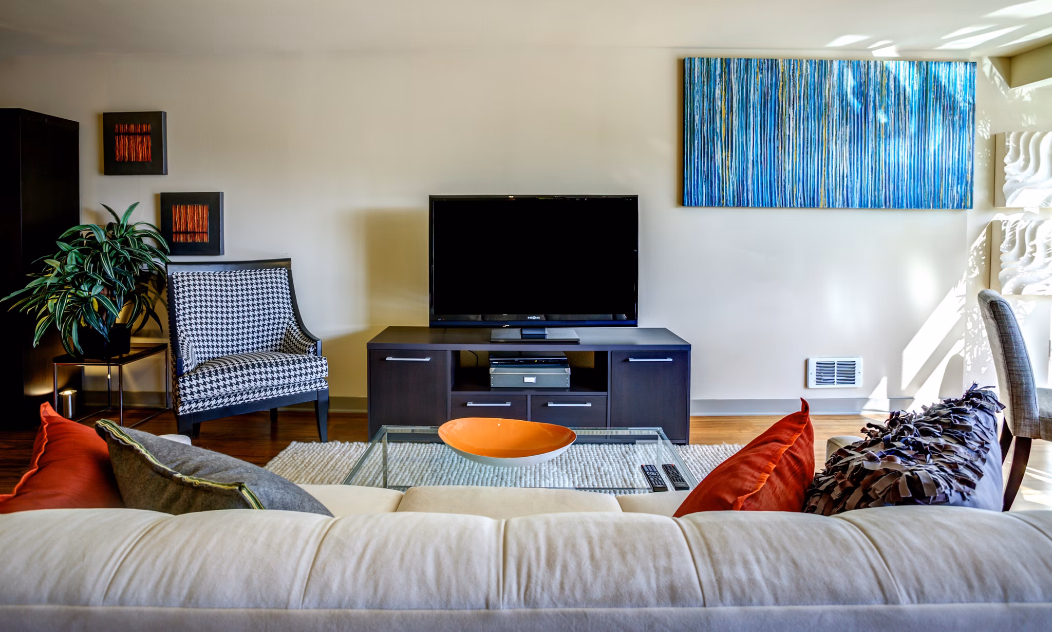 Living room with modern furnishings and ample natural light in Equinox Apartments