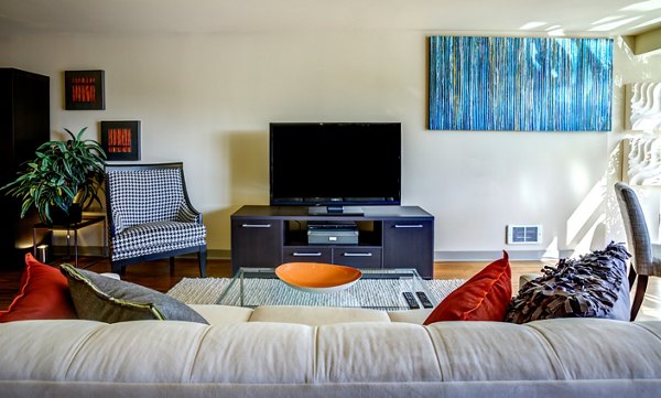 Living room with modern furnishings and ample natural light in Equinox Apartments