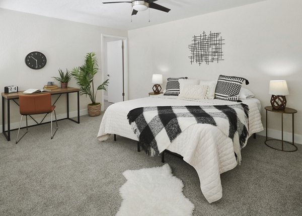 Cozy bedroom with stylish decor and large window at The Woodlands Apartments