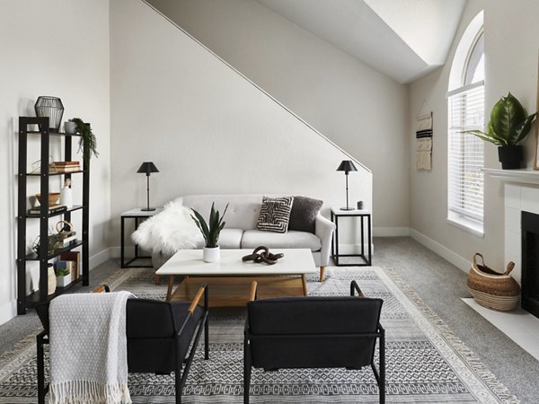 Spacious living room with modern decor and large windows in The Woodlands Apartments