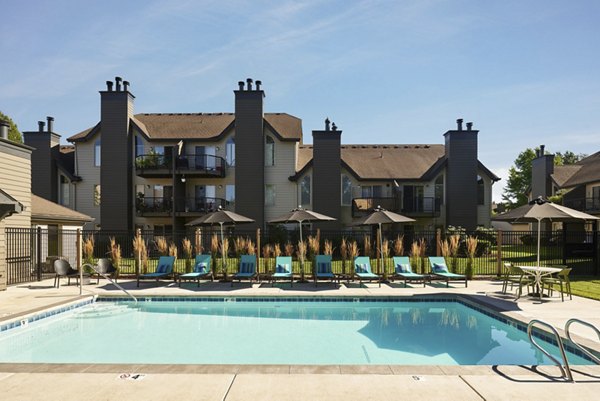 Luxury pool surrounded by lush landscaping at The Woodlands Apartments, offering relaxation and recreation for residents