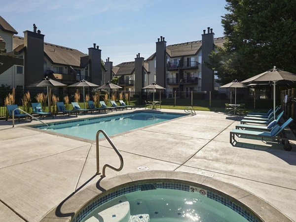 Resort-style pool with loungers at The Woodlands Apartments, perfect for relaxing in a luxury setting