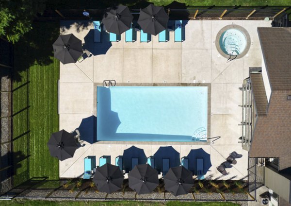 Resort-style pool with loungers and lush landscaping at The Woodlands Apartments, offering luxury living experiences