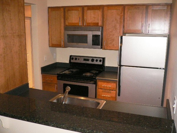 Contemporary kitchen with stainless steel appliances at Post Alley Court Apartments