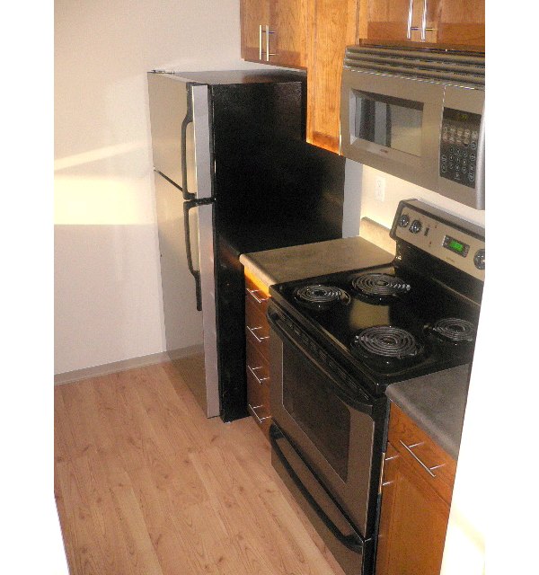 Modern kitchen with stainless steel appliances in Post Alley Court Apartments