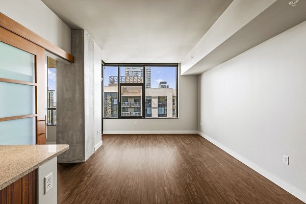 Living room with modern decor and large windows at Via 6 Apartments