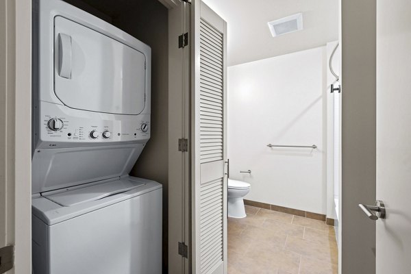Modern laundry room with sleek appliances at Via 6 Apartments, providing convenience in luxury living spaces