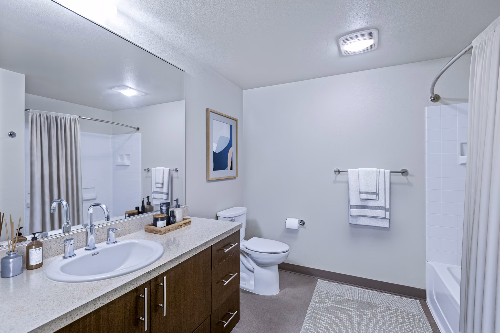 Modern bathroom with sleek fixtures and large mirror in Allez Apartments