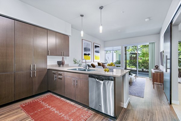 Kitchen featuring stainless steel appliances and granite countertops in Allez Apartments' luxury space