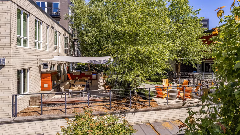 Outdoor grill area with patio seating at Allez Apartments luxury community