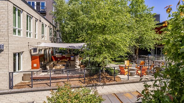 Outdoor grill area with patio seating at Allez Apartments luxury community