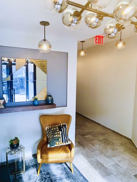 Hallway featuring exposed brick and modern lighting at The Atlantic Stamp Building Apartments in a luxury setting