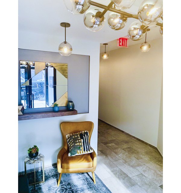 Hallway featuring exposed brick and modern lighting at The Atlantic Stamp Building Apartments in a luxury setting
