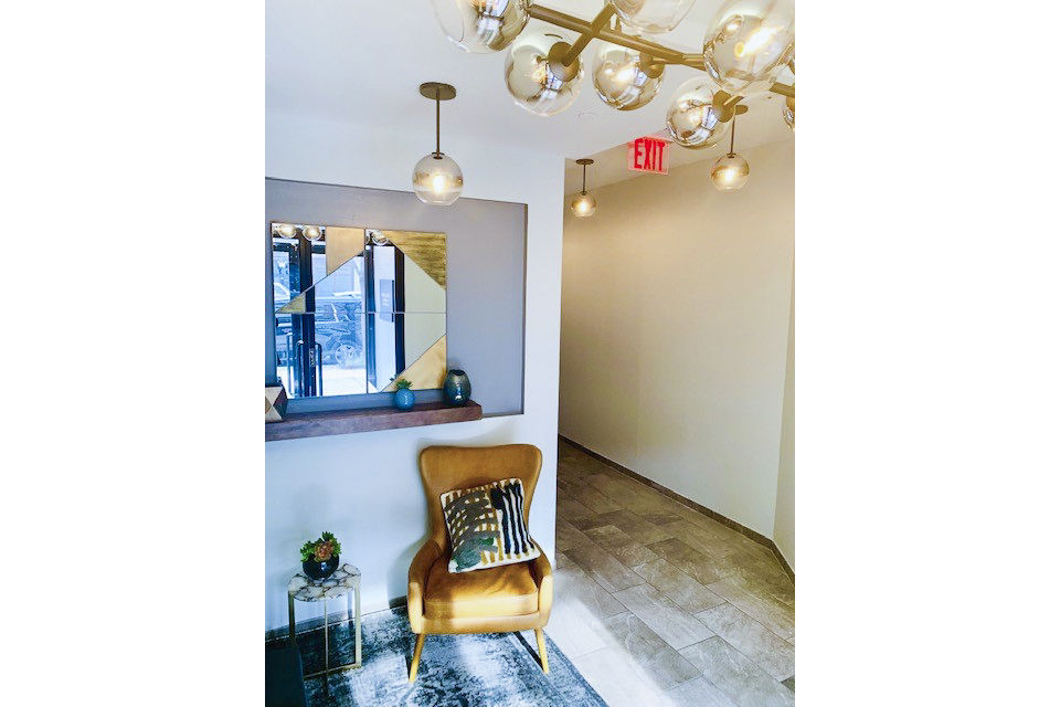 Hallway featuring exposed brick and modern lighting at The Atlantic Stamp Building Apartments in a luxury setting