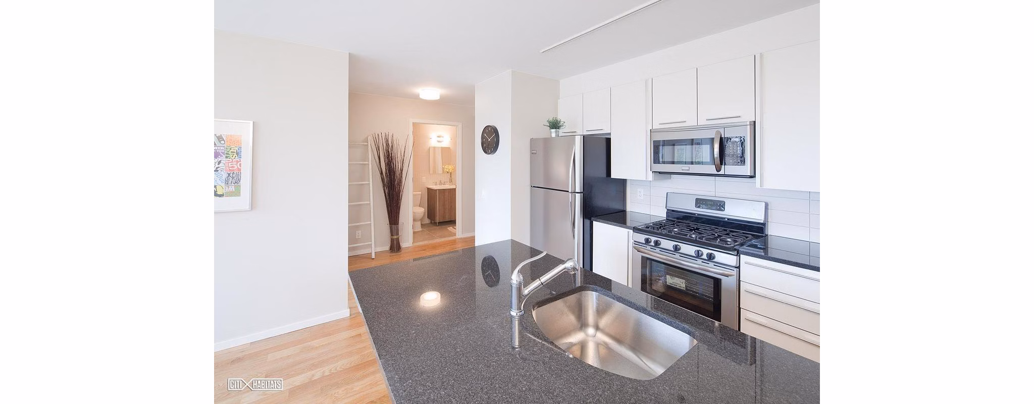 The Atlantic Stamp Building Apartments: Modern kitchen with stainless steel appliances and island seating in luxury Greystar community
