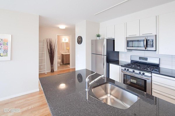 The Atlantic Stamp Building Apartments: Modern kitchen with stainless steel appliances and island seating in luxury Greystar community