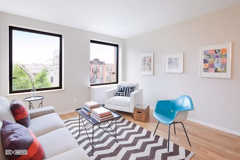 Spacious living room at The Atlantic Stamp Building Apartments featuring modern decor and large windows