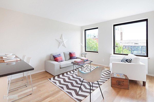 Elegant living room with exposed brick and modern dÃ©cor in The Atlantic Stamp Building Apartments, luxury homes by Greystar