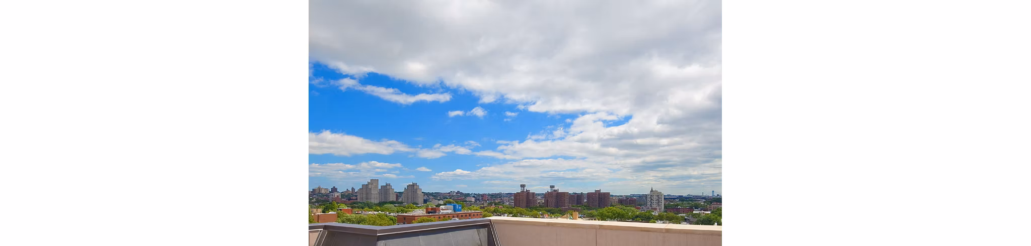 Cityscape featuring luxury apartments, lush trees, and a partly cloudy sky