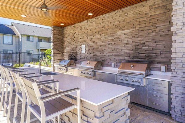 Outdoor grill and seating area at Avana One Zero Nine Apartments