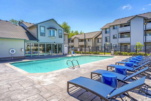 Poolside oasis at Avana One Zero Nine Apartments with lounge chairs and lush greenery