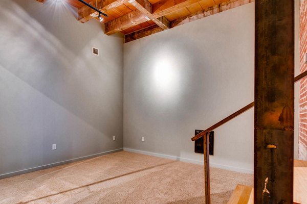 Cozy bedroom with exposed brick walls and modern furnishings in Albers Mill Lofts Apartments