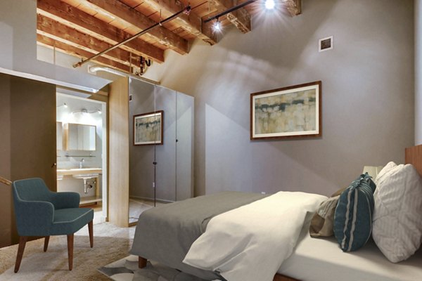 Cozy bedroom with large windows in Albers Mill Lofts Apartments, offering luxury living spaces in a vibrant community