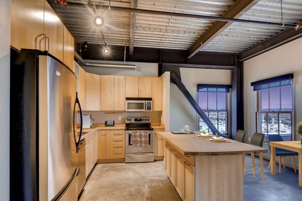 Modern kitchen featuring stainless steel appliances and granite countertops at Albers Mill Lofts Apartments Located in vibrant waterfront area