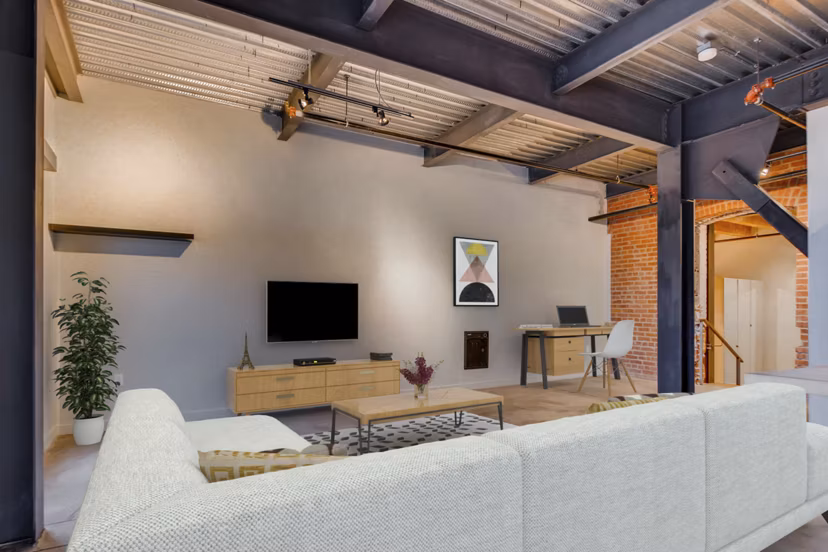 Charming living room with exposed brick and timber beams in Albers Mill Lofts Apartments