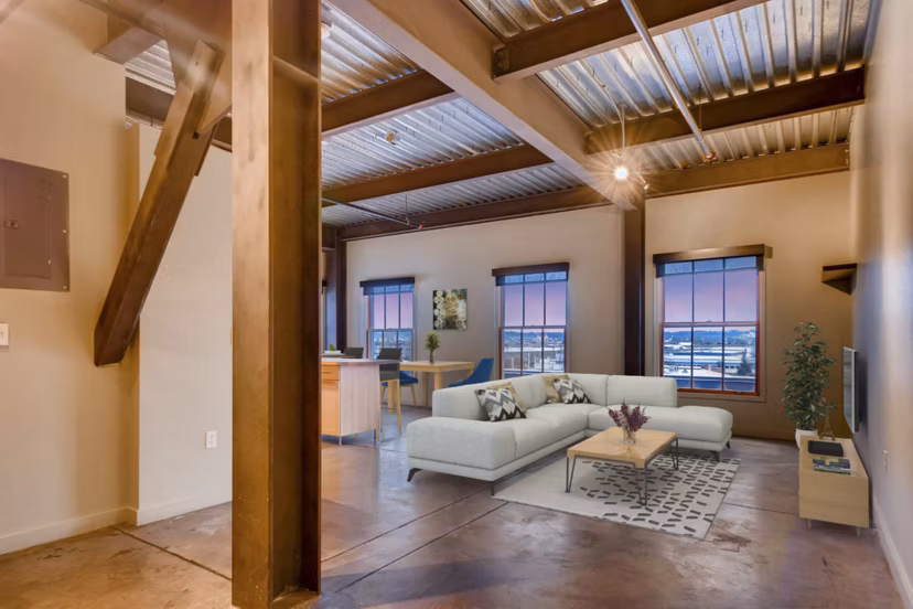 Spacious living room with exposed brick walls and modern design in Albers Mill Lofts Apartments